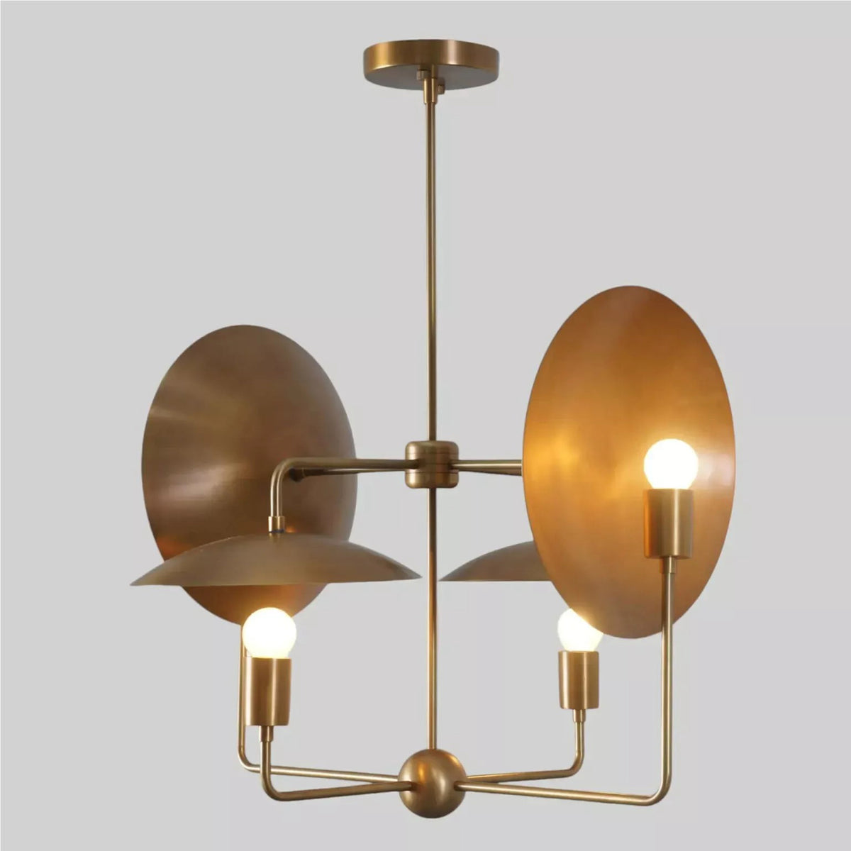 Perspective view of the Aurora Sculptural Disc Chandelier showcasing asymmetrical metal disc reflectors, exposed bulbs, and elegant brass framework.