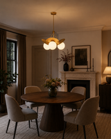 Aurora 3-light petal globe chandelier displayed above a dining table in an elegant warm-toned dining room interior.