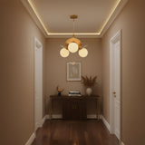 Side view of Aurora sculptural chandelier with three globe lights, decorative brass petals and rod suspension.
