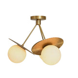 Angled view of Aurora 3-light semi-flush chandelier with textured brass petals and opal glass globes