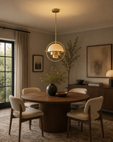 Aurora 1 light brass pendant chandelier displayed above a round dining table in a warm modern dining room
