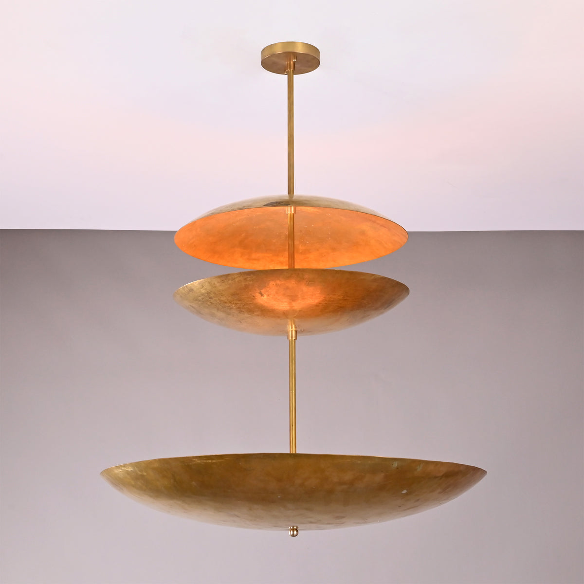 Angled view of Aurora Triple Saucer Chandelier showing sculptural three tier shade arrangement.