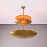 Close up of Aurora Triple Saucer Chandelier highlighting layered saucer shades and warm diffused illumination.