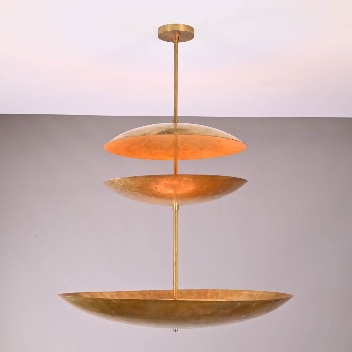 Front view of Aurora Triple Saucer Chandelier with three stacked saucer shades and warm layered glow.