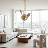 Avignon 3 light brass tone sculptural chandelier shown from an angled view with three circular metal disc shades.