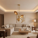 Avignon 3 light brass tone chandelier featuring asymmetric circular disc shades with illuminated bulbs.