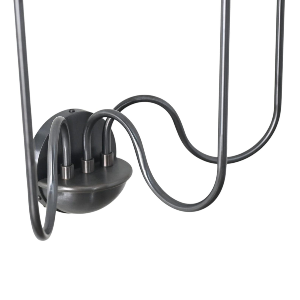Close-up of the sconce’s rounded black metal base with three elegantly curved connecting arms showing refined craftsmanship and sturdy construction.