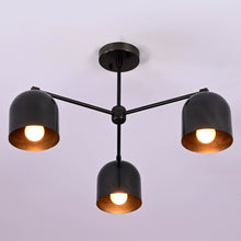 Modern 3-light black brass ceiling chandelier with dome-shaped shades, photographed in daylight against a white ceiling.