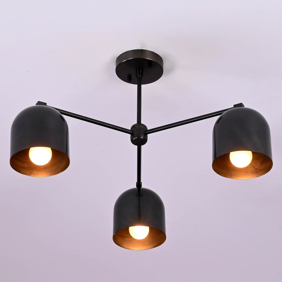 Modern 3-light black brass ceiling chandelier with dome-shaped shades, photographed in daylight against a white ceiling.