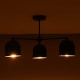 Black dome chandelier with three glowing lights, radiating warm beams in a dimly lit room.