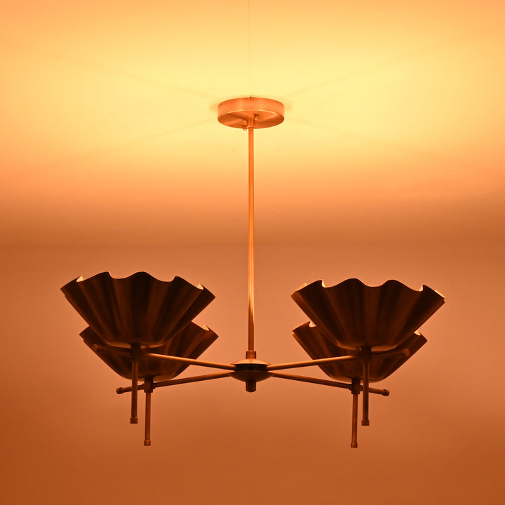 Brass bloom chandelier providing ambient golden light in the evening, enriching the room’s atmosphere.