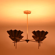 Brass bloom chandelier providing ambient golden light in the evening, enriching the room’s atmosphere.