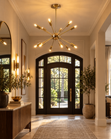 Bologna 12-light gold Sputnik chandelier hanging in an elegant entryway with arched glass doors, warm lighting, and contemporary interior decor.