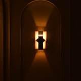  Boston 2-light architectural wall sconce illuminated at night, creating dramatic warm light patterns above and below its dark rectangular metal body.