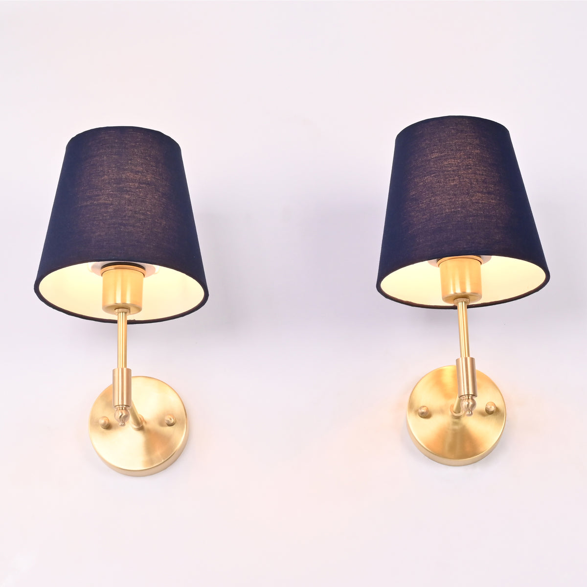 Bottom perspective of the antique brass wall sconce highlighting the rich blue fabric shade, brass socket, and warm downward light.