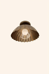 Underside view of brass scalloped dome ceiling light showing petal-edge bowl shade and central clear globe bulb.