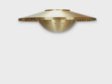 Minimal studio shot of modern brass disc flushmount ceiling light with clean lines and warm ambient glow.