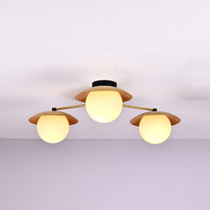 Handmade brass chandelier with three frosted globe bulbs and brushed brass disc shades, modern ceiling light fixture with minimalist design.