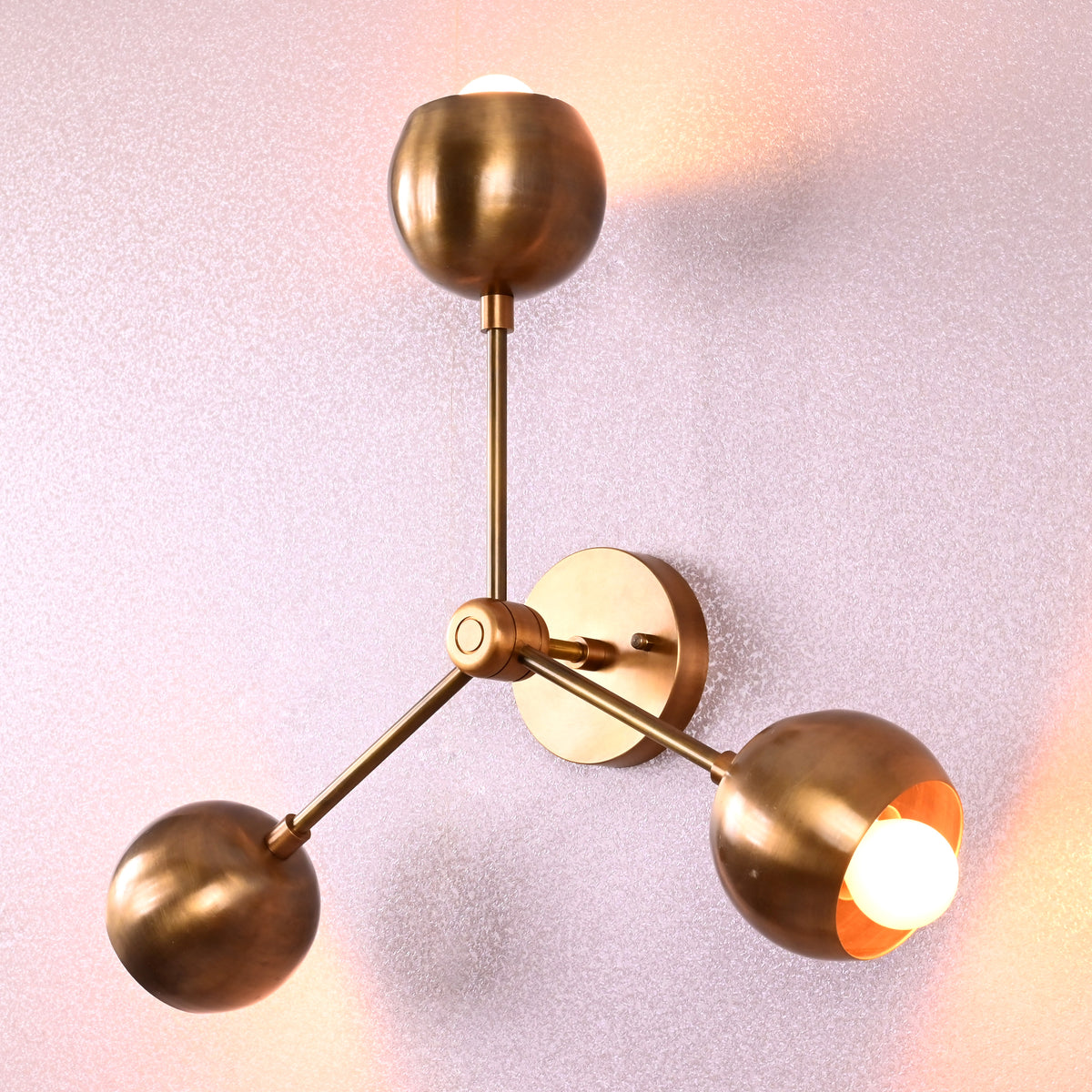 Stylish brass ceiling lamp with three spherical shades arranged in a triangular flush mount design, photographed in brushed brass finish.