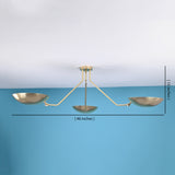 Brass flushmount chandelier measuring 46 inches wide and 15 inches high, with three bowl-shaped shades, displayed against a blue wall background.