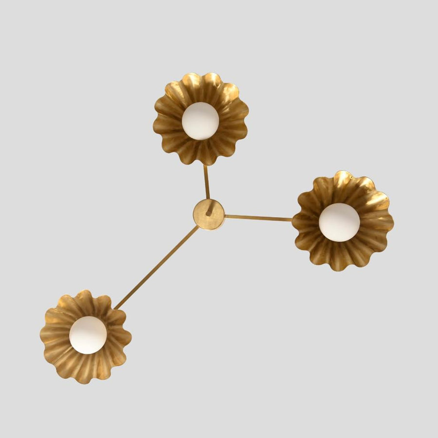 Handmade brass chandelier with three ruffled shades and white globes, viewed from the front, showcasing its elegant modern design.