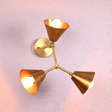 Elegant brass wall sconce with three conical shades arranged in a triangular pattern, designed by Brass Leaf Studio.