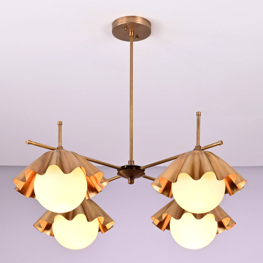 Handmade brass chandelier with four sculpted ruffled shades and frosted globe bulbs, modern ceiling light fixture for living and dining spaces.
