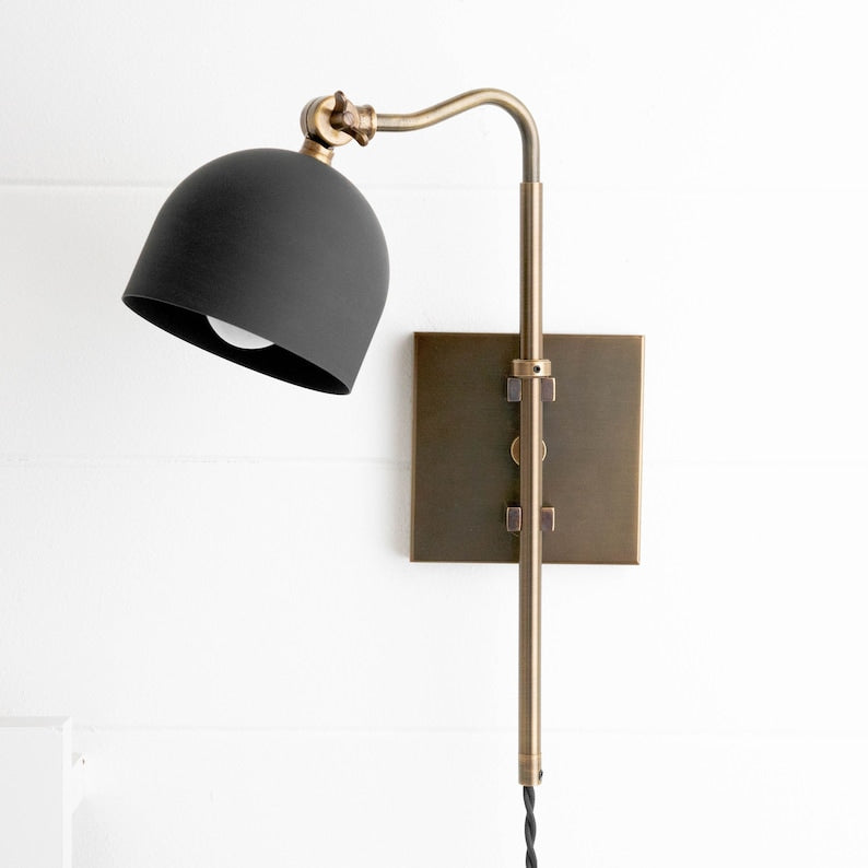 Adjustable solid brass wall sconce with matte black dome shade on square backplate, modern industrial wall light