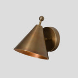 Angled view of a cone-style brass wall light with a ball finial and round backplate, designed for modern interiors.