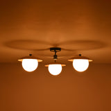 Brass 3-light chandelier with frosted globe bulbs glowing warmly at night, creating soft ambience for modern and classic interiors.