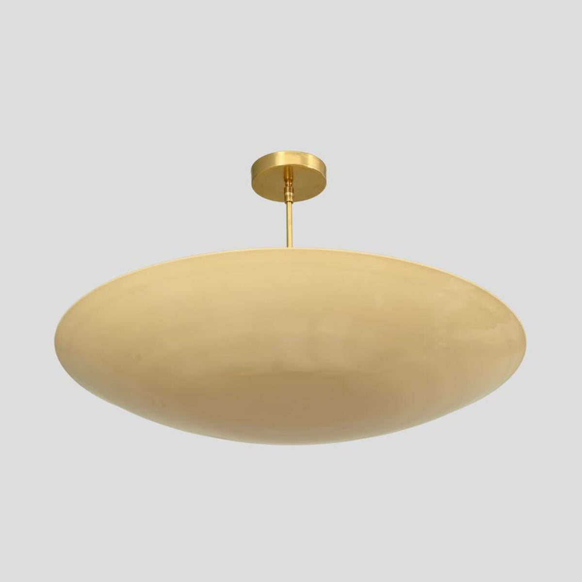 Brass dome flushmount light providing warm ambient glow with minimalist handmade design.