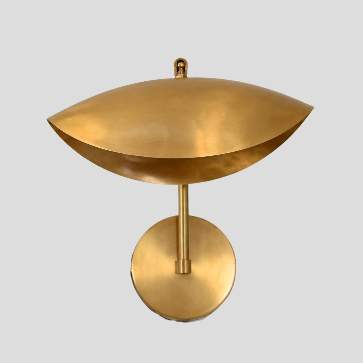 Handcrafted brass wall sconce with wide dome shade, front-facing view highlighting smooth satin brass finish.