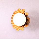 Angled top view of brass flower wall light with round bulb and scalloped petal design in brushed brass finish.