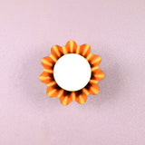 Handmade brass flower-shaped wall light with round bulb, viewed from the front, designed by Brass Leaf Studio.