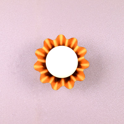 Handmade brass flower-shaped wall light with round bulb, viewed from the front, designed by Brass Leaf Studio.