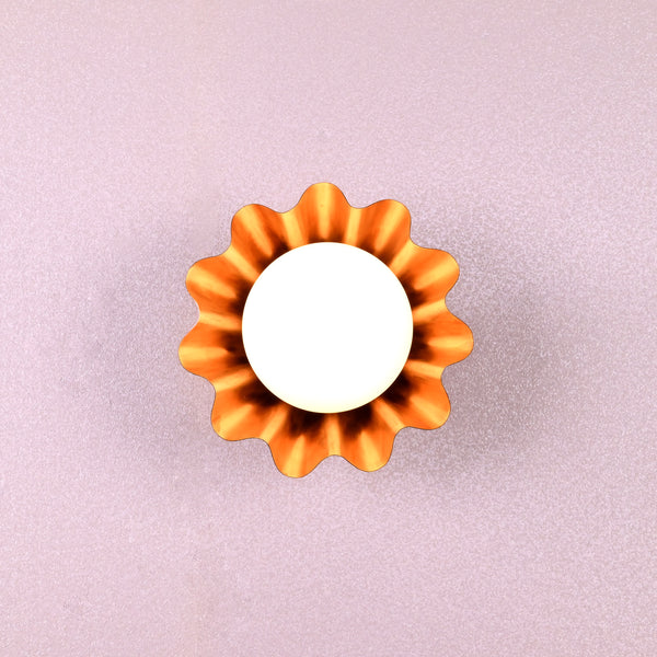 Handmade brass flower-shaped wall light with round bulb, viewed from the front, designed by Brass Leaf Studio.
