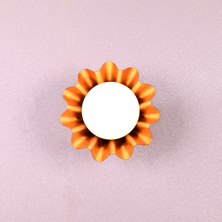 Handmade brass flower-shaped wall light with round bulb, viewed from the front, designed by Brass Leaf Studio.