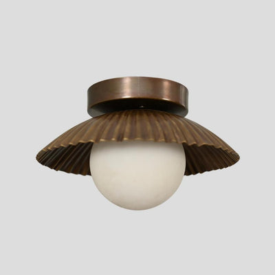 Handmade brass flush mount light with a scalloped shade design, featuring a round white bulb and antique finish, ideal for living rooms and entryways.