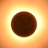 Underside view of brass flushmount ceiling light creating circular ambient glow on ceiling