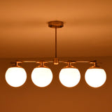 Brass chandelier with four frosted globe shades glowing warmly in dim light, providing cozy illumination for modern interiors.