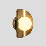 Modern brass wall sconce with frosted glass globe lit up, highlighting warm ambient glow and brushed brass frame.