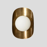 Vertical front view of handmade brass wall sconce with frosted glass globe shade set in brushed brass frame.