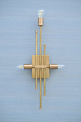 Front view of brass linear wall sconce with geometric rod arrangement and three light holders, handmade luxury wall lighting.