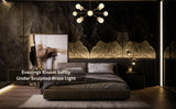 Dark luxury bedroom with a brass Sputnik chandelier, dramatic wall textures, and a modern bed arrangement.