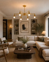Brighton 6 light brass chandelier illuminating a refined modern lounge with neutral furniture and warm interior styling.