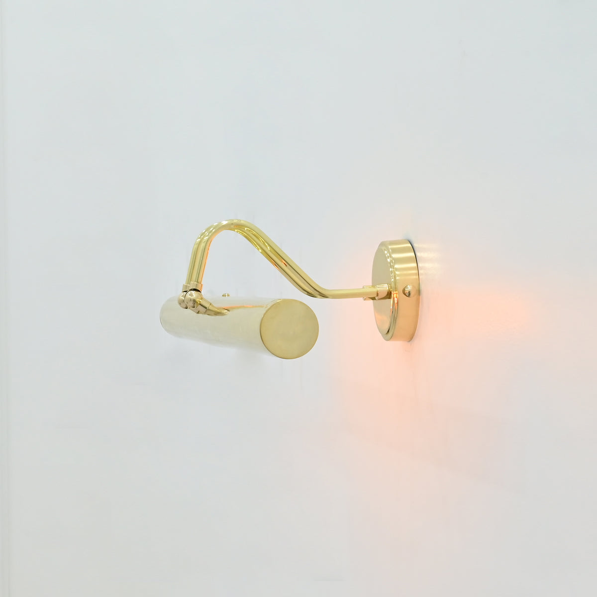 Side profile of Brisbane 4 light polished brass wall-mounted picture light showing decorative curved arms and cylindrical metal shade.