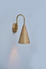 Handmade brushed brass cone wall sconce showing side angle with smooth satin finish and warm downward lighting.