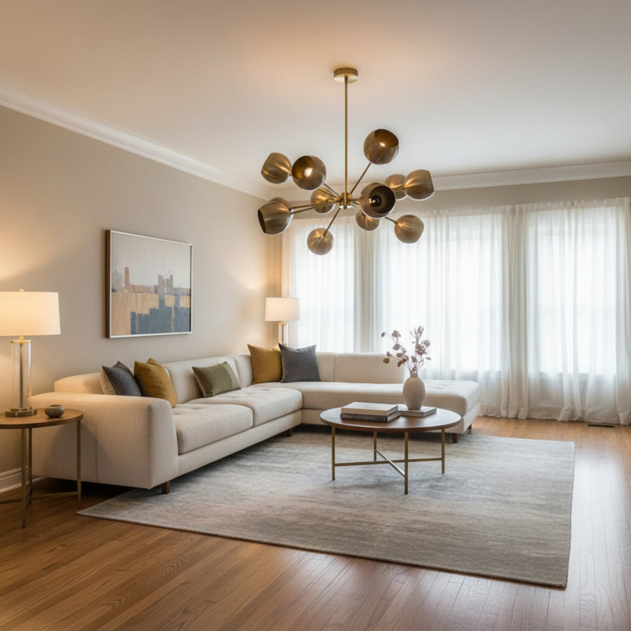 Brussels 12 light aged brass sculptural globe chandelier shown from the front with radiating arms and rounded metal shades.