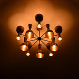 Low angle view of Cairo Diabolo chandelier with glowing shades, radial arms, and warm ambient ceiling light.