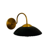 Angled view of Cambria black fluted dome wall light with brass canopy and curved arm – Model 32785